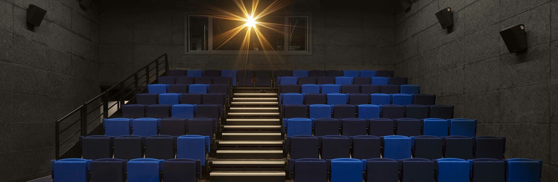 Un amphithéâtre aux sièges bleus et noirs