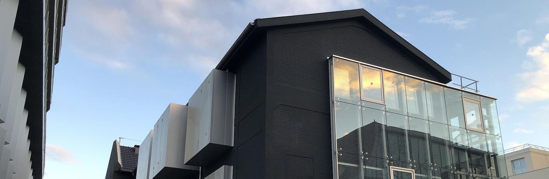 La façade arrière du Lavoir, peinte en noir avec excroissances alu et verre