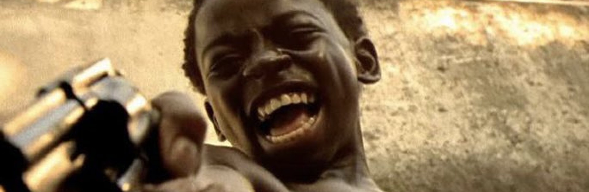 Un enfant tient un pistolet en riant
