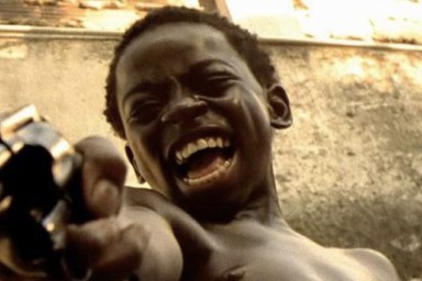 Un enfant tient un pistolet en riant