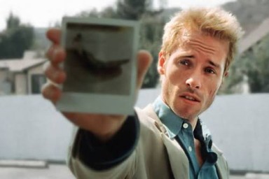Un homme tend un polaroid. 
