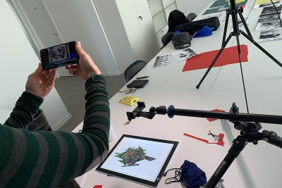 Un enfant dont on ne voit que les mains filme avec son téléphone des éléments de décor - Agrandir l'image 5 sur 6, fenêtre modale