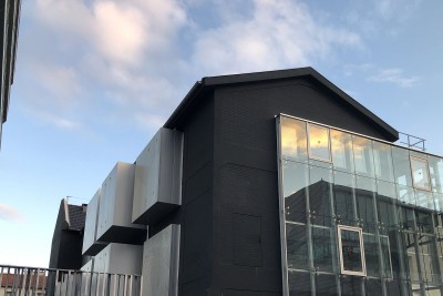 La façade arrière du Lavoir, peinte en noir avec excroissances alu et verre - Agrandir l'image 1 sur 3, fenêtre modale